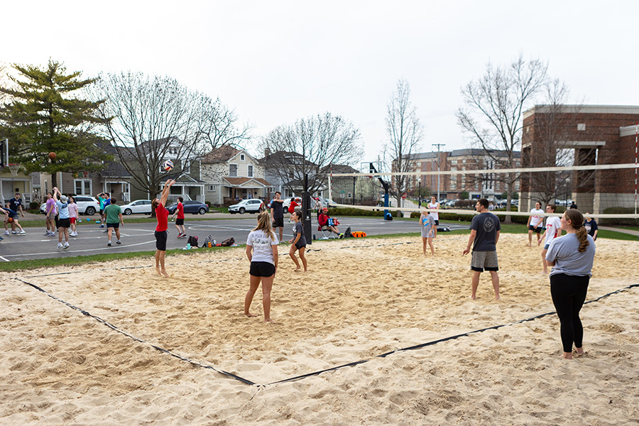 Students playing sand volleyball and basketball