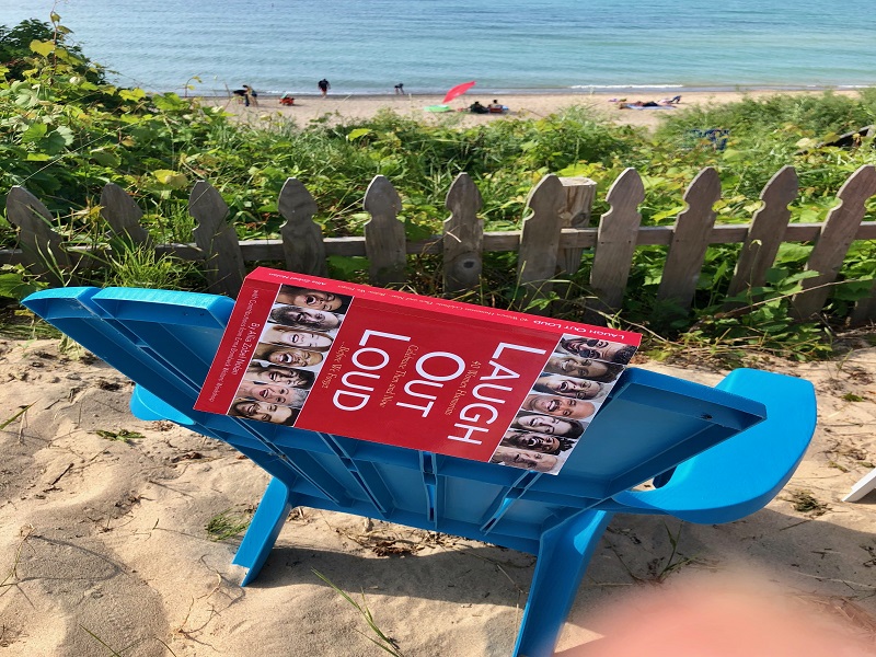 Laugh out Loud book draped over a beach chair