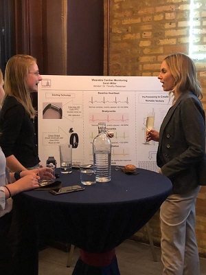 Alumni look at student posters and research projects during the Chicago networking event.