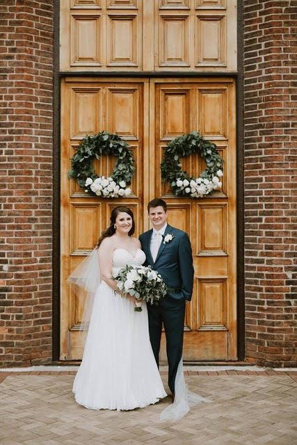 Mr. and Mrs. Doyle stand in front of the Chapel doors for a wedding photo.