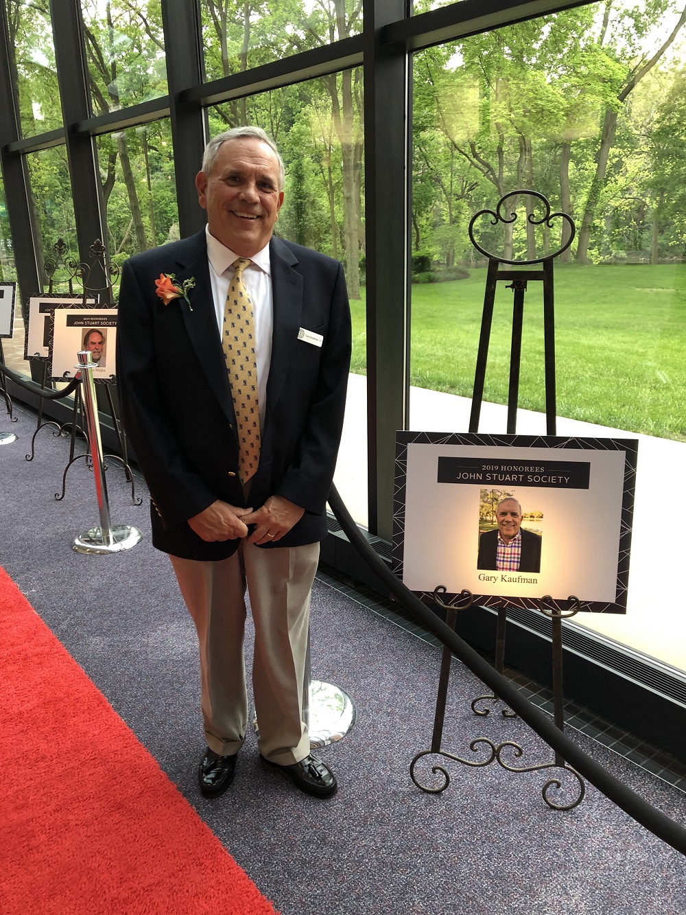 Gary Kaufman stands next to his John Stuart Society induction poster.