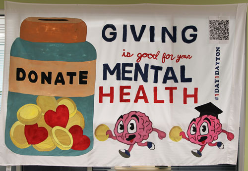 Little brains running toward a donation jar saying "Giving is good for your mental health"