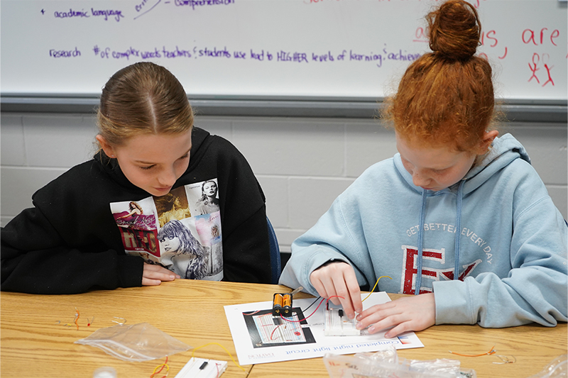 Two young students working with a circuit 