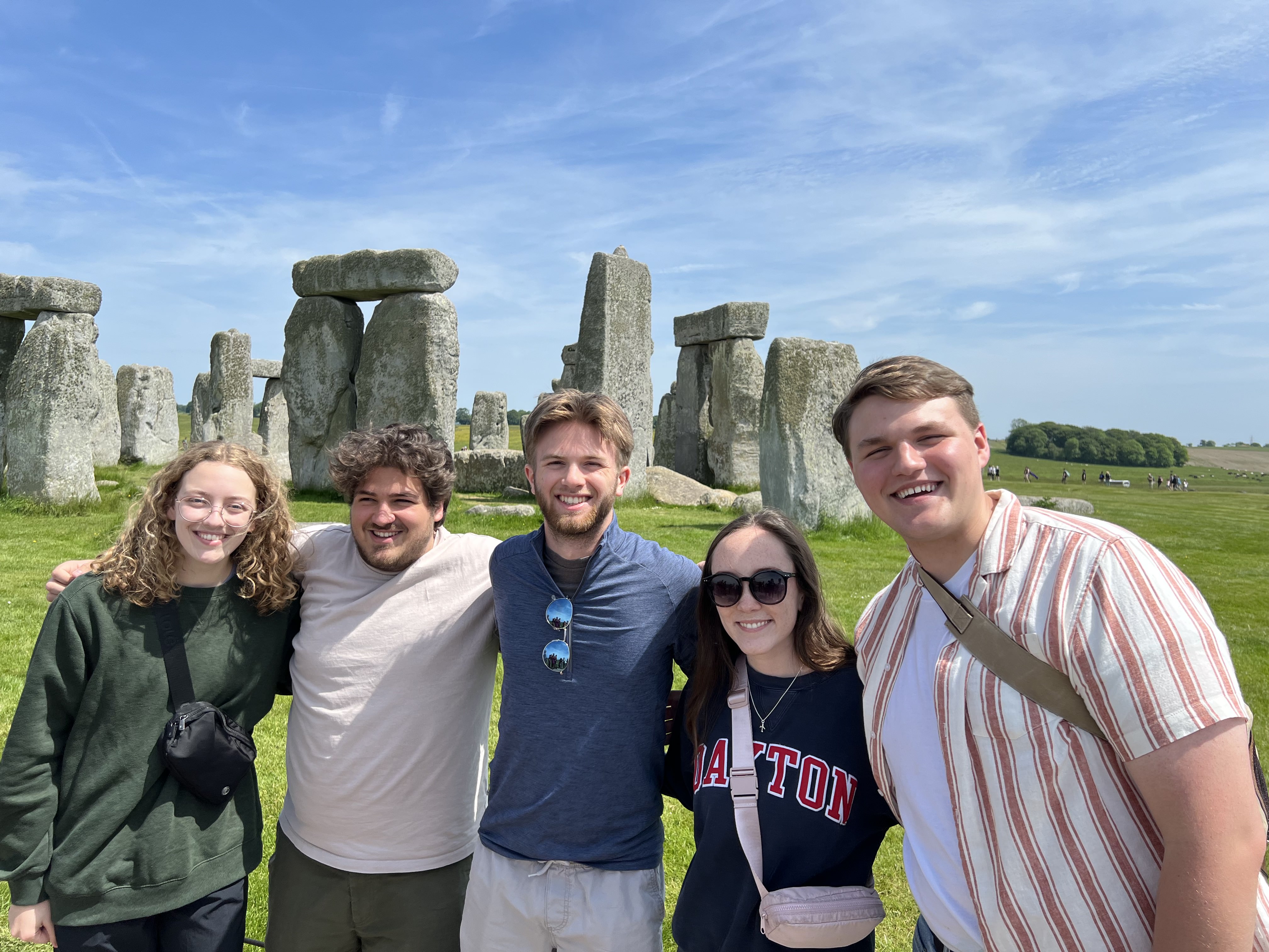 Five students standing in front of Stonehenge in the United Kingdom. 