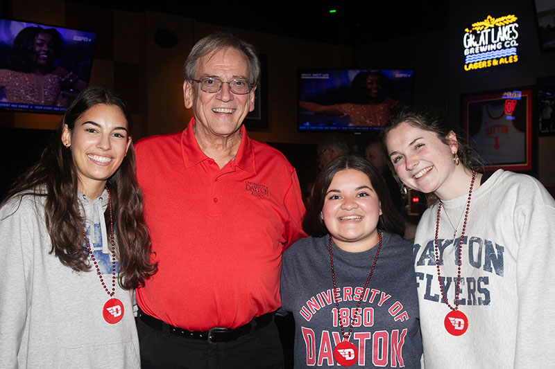 Leah Swayne (left) at the gamewatch with an alumnus and two Students for University Advancement members. 