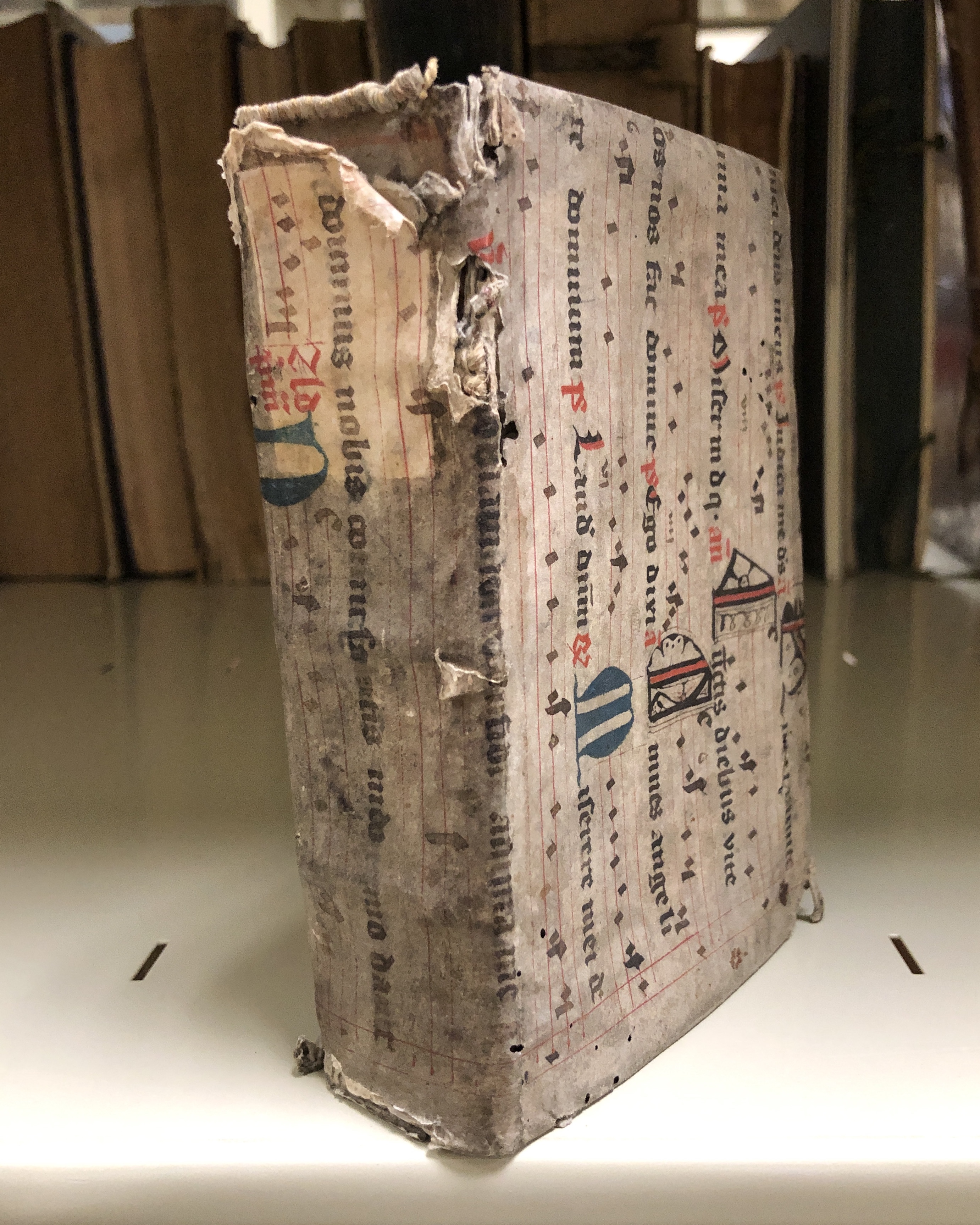 The initials, text and musical notation that cover the boards on this 1509 book, a collection of Johannes Aquilanus’ sermons, remain visible in spite of grime and bookworm damage.