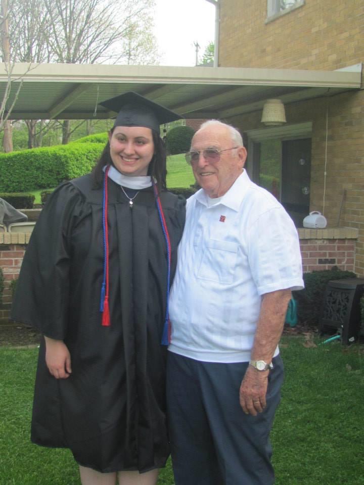 Stacie and her grandfather posing after her graduation.