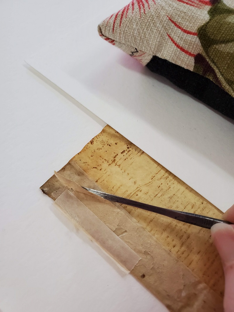 Removing adhesive from a medieval leaf