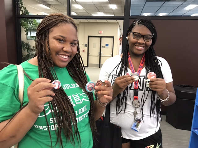 Two students show off their newly made buttons.