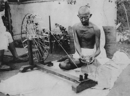 Photo of Mohandas Gandhi spinning cloth