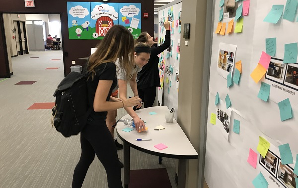 Students offering furniture feedback on sticky notes