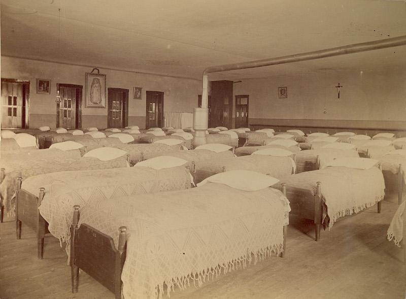 Rows of neatly made bed in a dormitory room