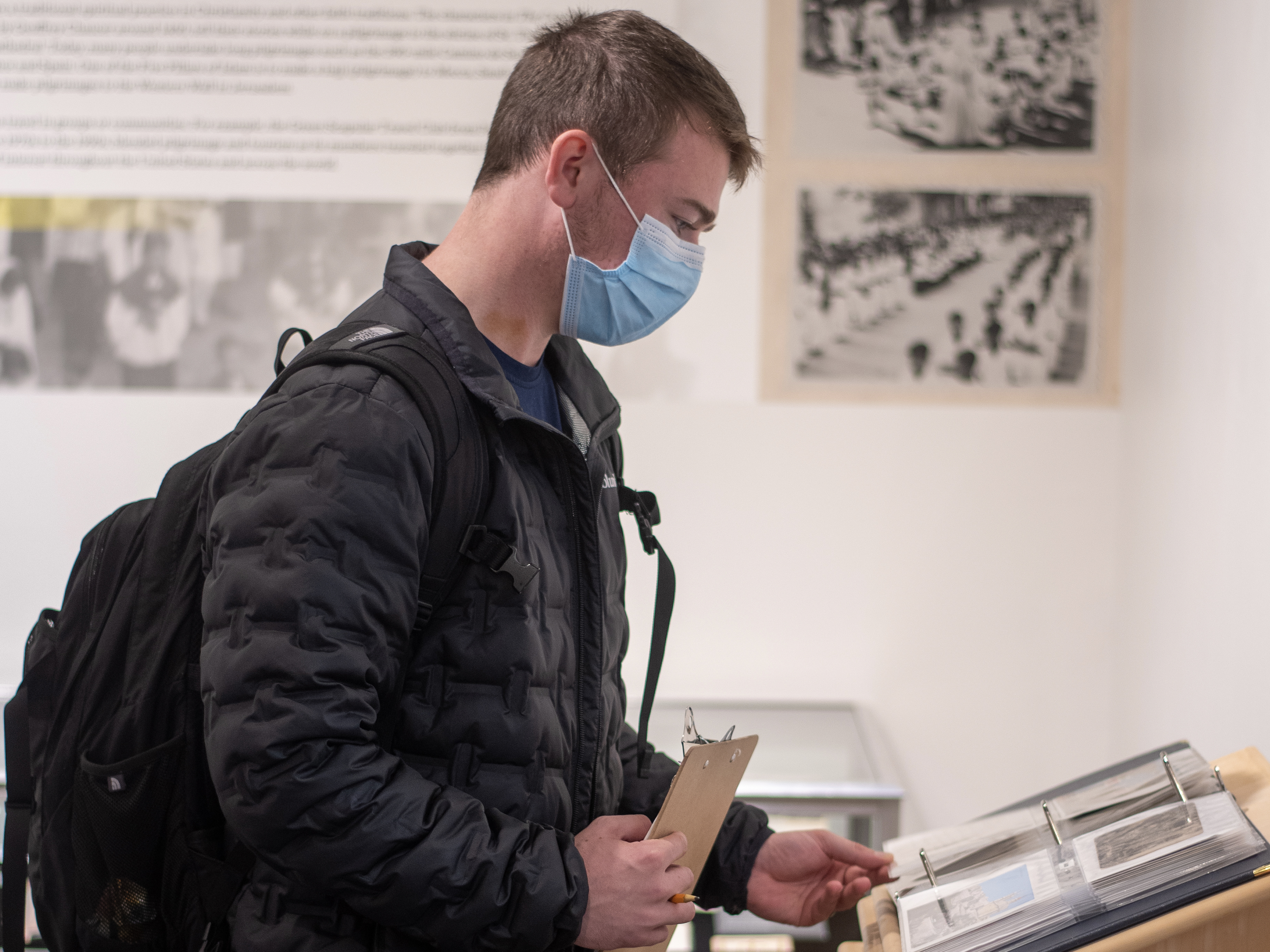 student looks at Marian library exhibit