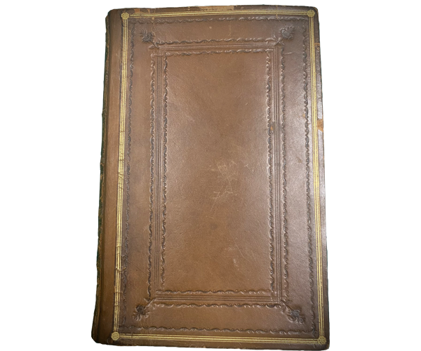 Closed Bible with brown leather cover with a decorative border.