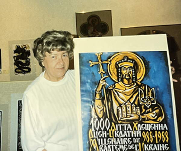 Nykolyshyn holding a blue poster containing Ukrainian text.