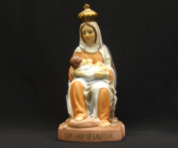 Statue of the crowned Madonna sitting with Infant Jesus resting on her lap while nursing. “Our Lady of Laleche” painted across the rounded base.