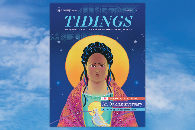 The front cover of "Tidings: An Annual Communique from the Marian Library" which features a depiction of the Blessed Virgin Mary with a large orange and yellow halo behind her head. Her dark hair is up in twists and ribbons. She is wearing a cloak of bright pinks, oranges with swirls and a turquoise layer underneath. She holds a white dove with a ribbon in it's beak. The teaser copy read: "Inside: Wayfinding in the Library; An Oak Anniversary; A Review of the Academic Year." Behind the cover is a blue sky background.