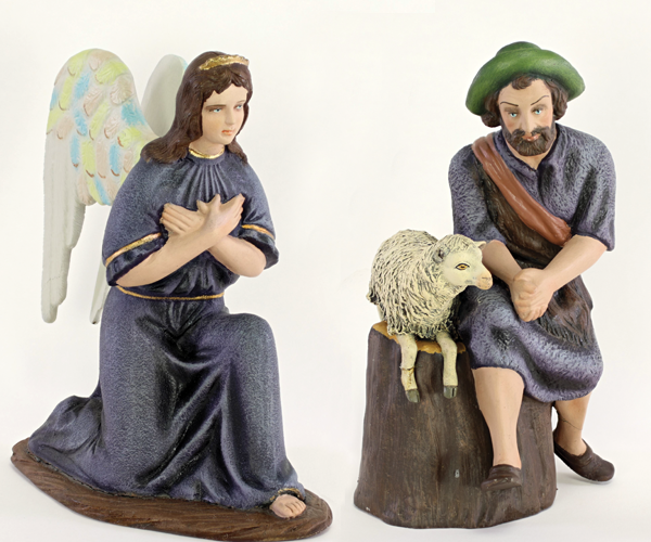 A female angel in a purple dress with white wings kneels with her arms crossed. A male shepherd sits on a tree stump next to a laying sheep.