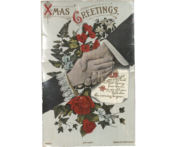 Christmas postcard featuring an image of a handshake between a man and woman. The man’s lower arm is covered by a black suit coat with the cuff of a white dress shirt showing. The woman’s lower arm is covered by a black sleeve trimmed in white lace with a gold beaded bracelet just below the sleeve edge. The background of the card has a bouquet of roses, lilies, forget-me-nots and poppies interspersed with ivy, spruce branches, and ferns. The Christmas message “Xmas Greetings” is printed at the top center of the card. The message continues onto a designed sheet of paper in a decorative script in red and gold that reads, “Bright joys of the earth and sweet blessings from heaven, May you and your loved ones this morning be given.” Printed along the bottom is the printer’s information: Left: “1066B/3.” Center: “COPYRIGHT.” Right: “Beagles’ Postcards.” 