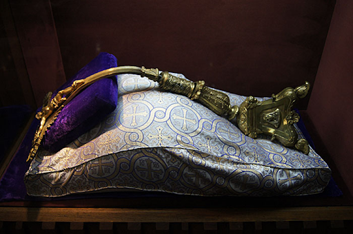 Bent bronze crucifix resting on a pillow