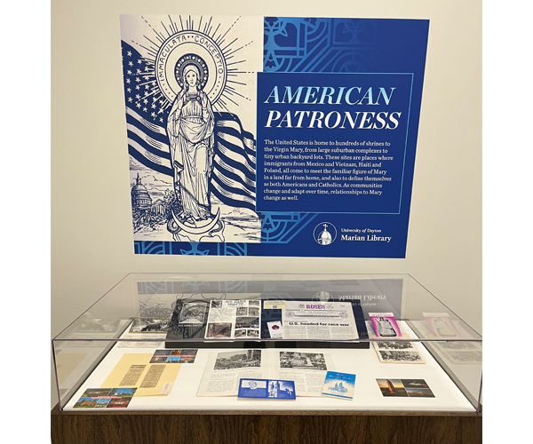 Display case filled with items and a sign above that reads "American Patroness" and has a description of what is in the case.