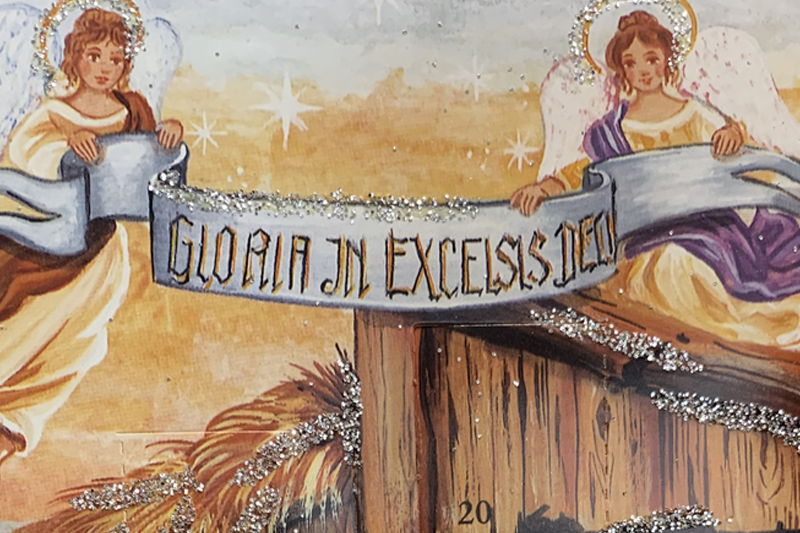 Two angels holding a banner that reads "gloria in excelcis deo"