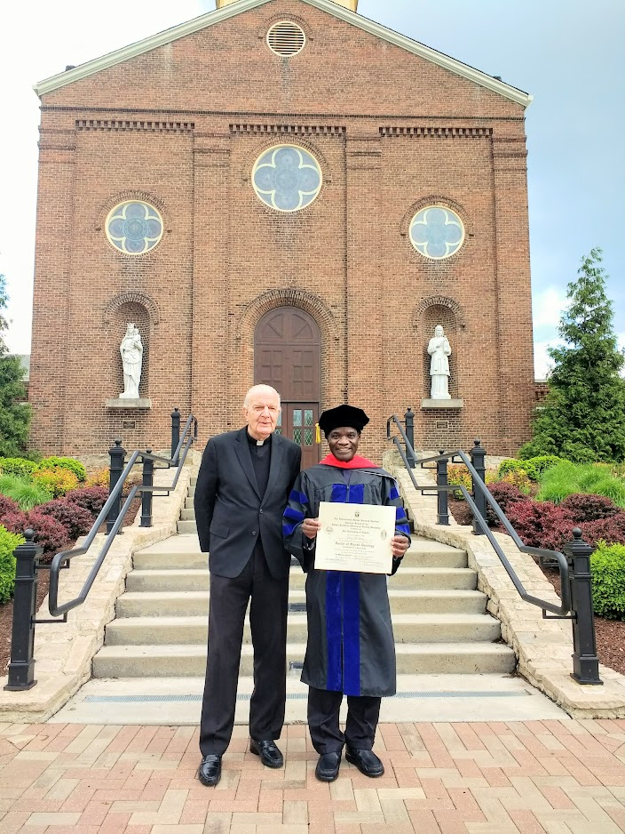 Father Johann Roten, S.M., and Father Henry Sseriiso in front of the Chapel of the Immaculate Conception at the University of Dayton.