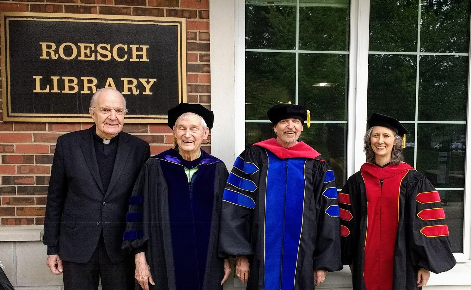 Photo, from left: Father Johann Roten, S.M., reader; Father Bertrand Buby, S.M., director; Stuart Schafer; Gloria Falcão Dodd, IMRI’s director of academic programs — in front of Roesch Library