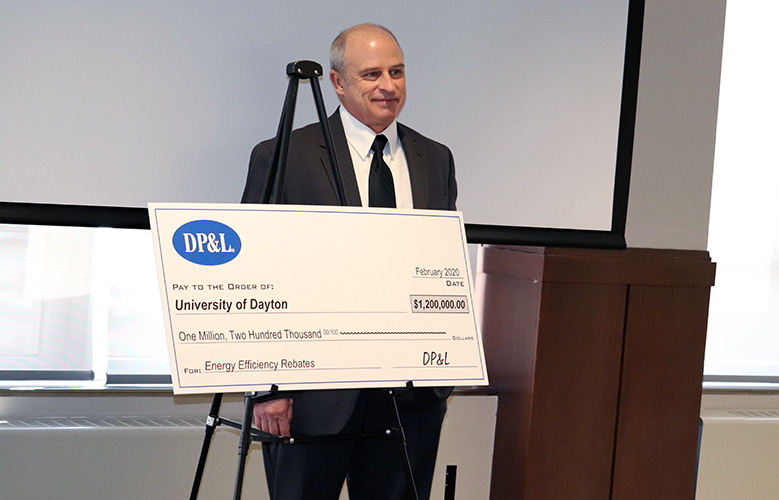 Steve Kendig, UD's executive director for energy utilization and environmental sustainability, poses with the check representing rebates from Dayton Power and Light.