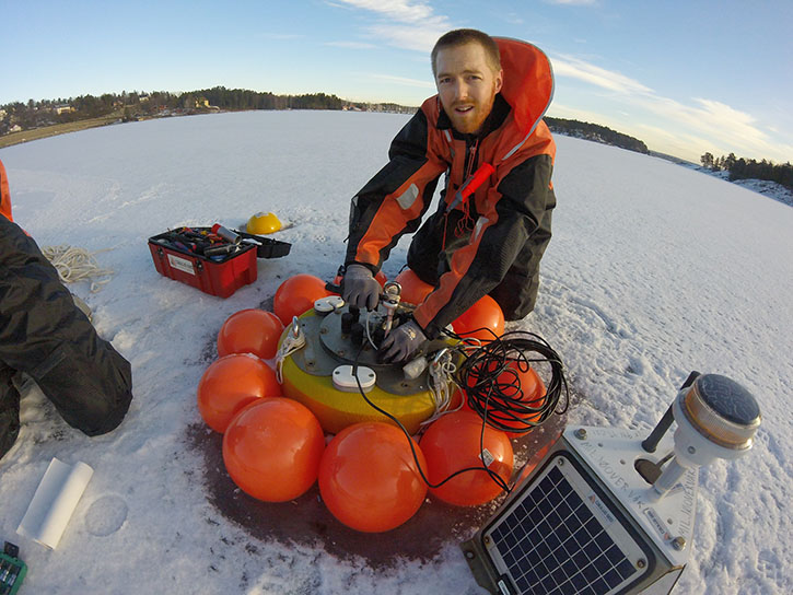 MIke Voellmecke, a 2011 University of Dayton graduate and the first with a minor in sustainability, does winter maintenance on a water quality monitoring data buoy.