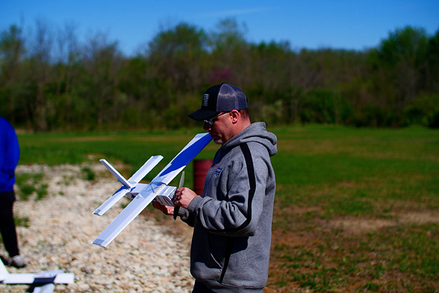 RC Pilot Chris Fry inspecting a student's airplane before flying