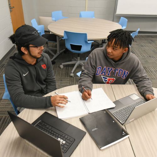 Two male students studying together at a table
