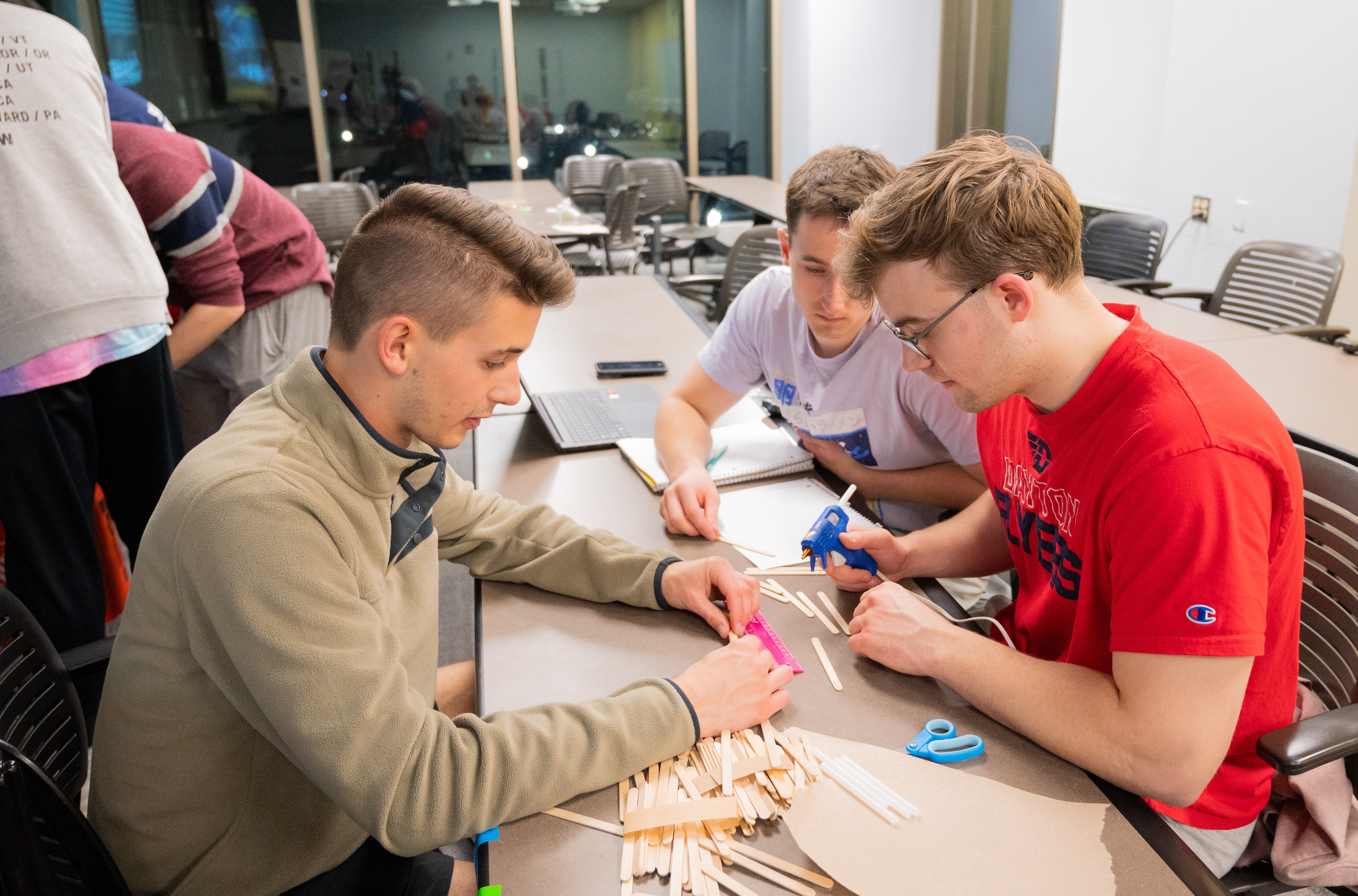 Winning student team constructing popsicle stick bridge