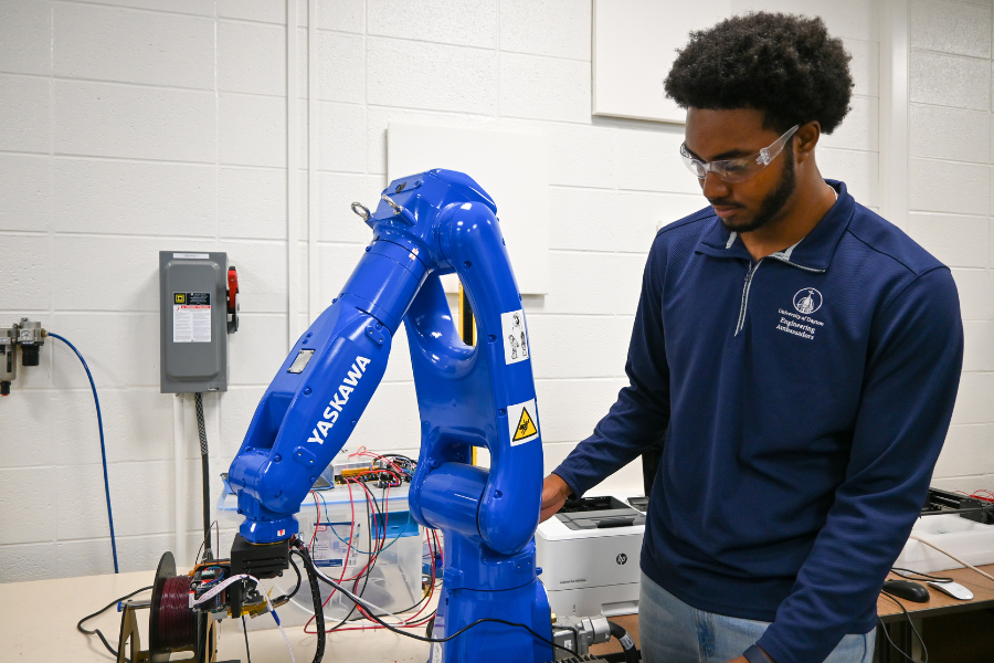 Student using a robotic arm equipment