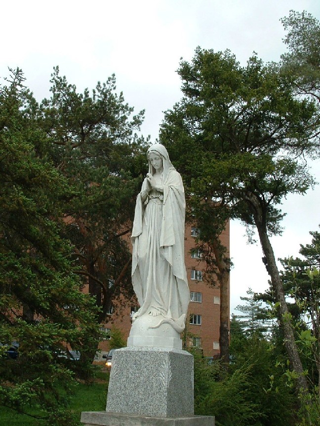statue of Mary, standing, head slightly bowed, hands in prayer