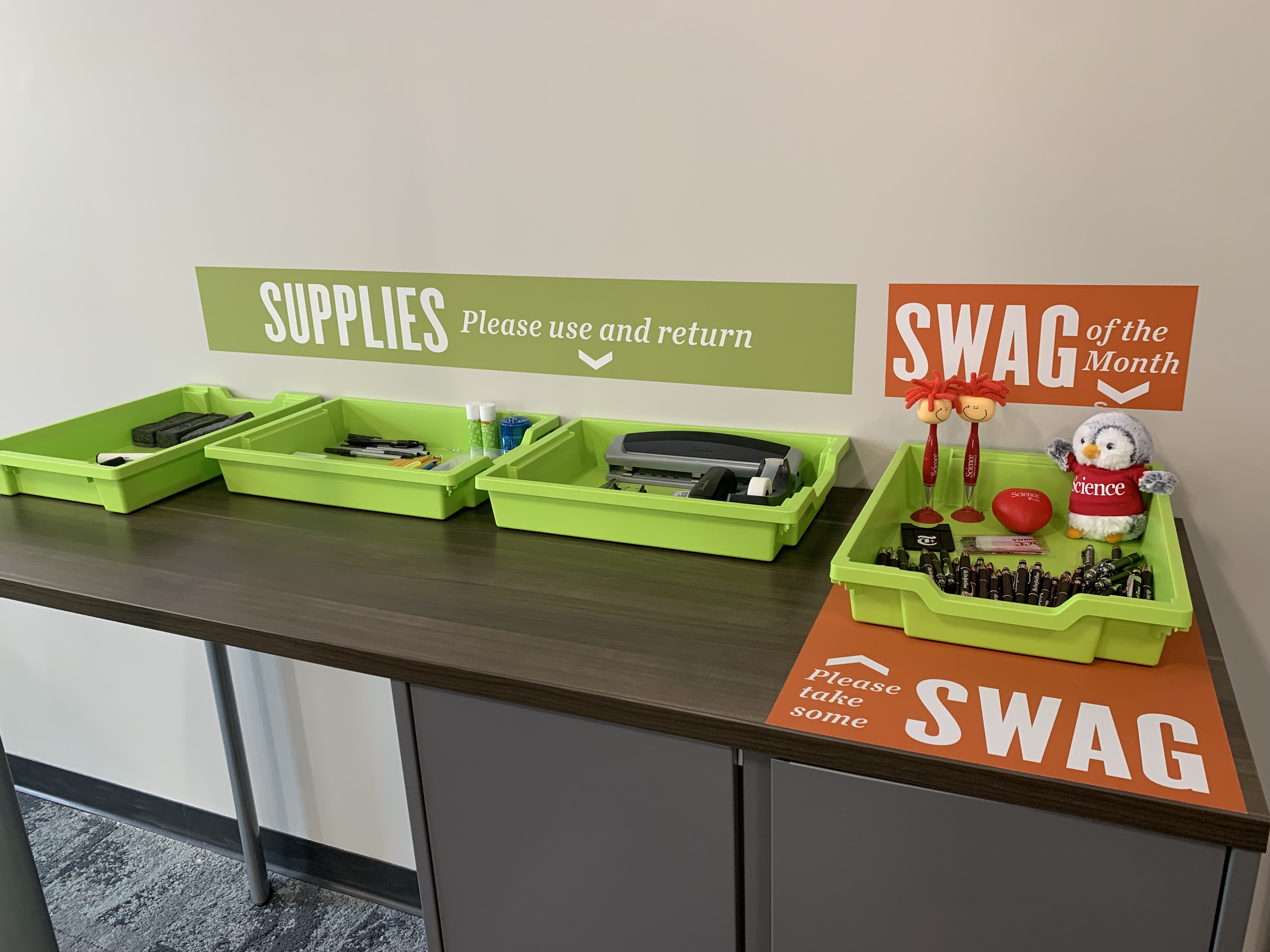 Office supplies and promotional swag organized in baskets on a tabletop