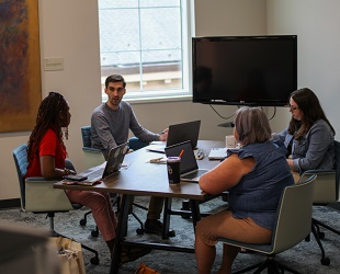 group of faculty working and talking at a table