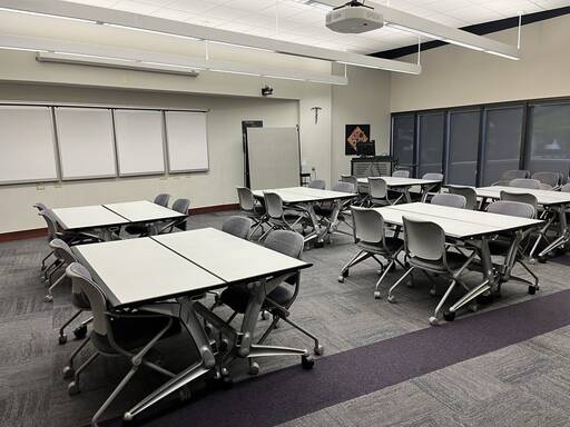 classroom called forum with tables and chairs setup in pods for four to six people each. 