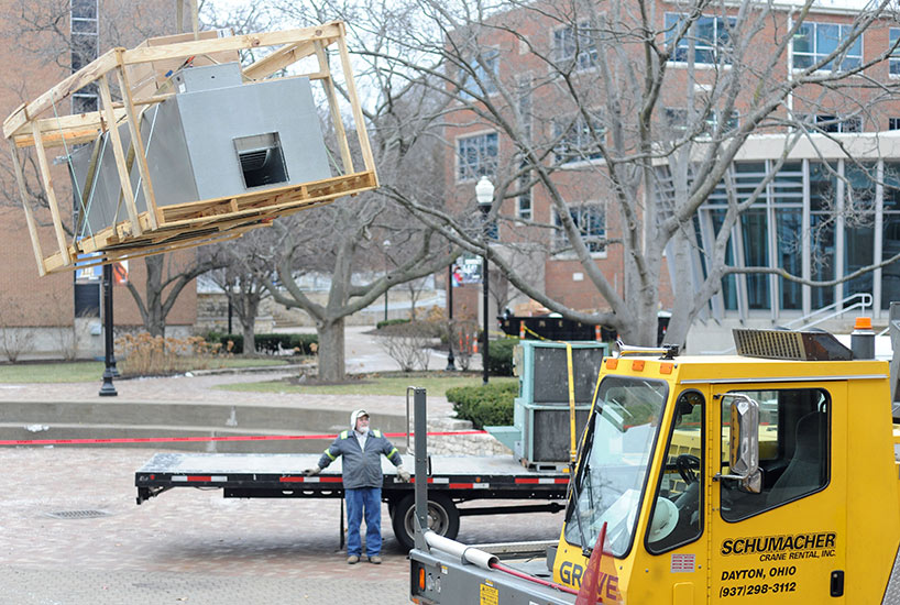 Crane lifts a new air handler off a truck