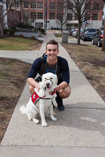 Student poses with dog.