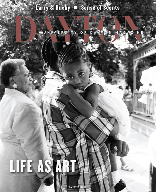 Cover of UD Magazine, girl in the arms of an adult