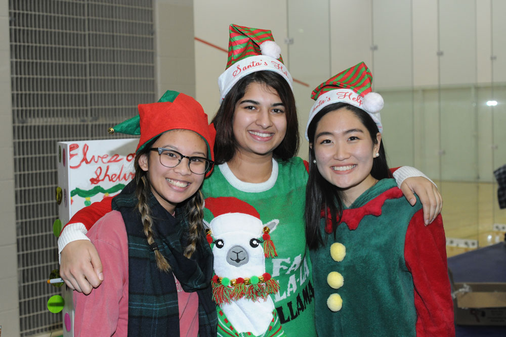 A group of students poses in festive Christmas outfits.
