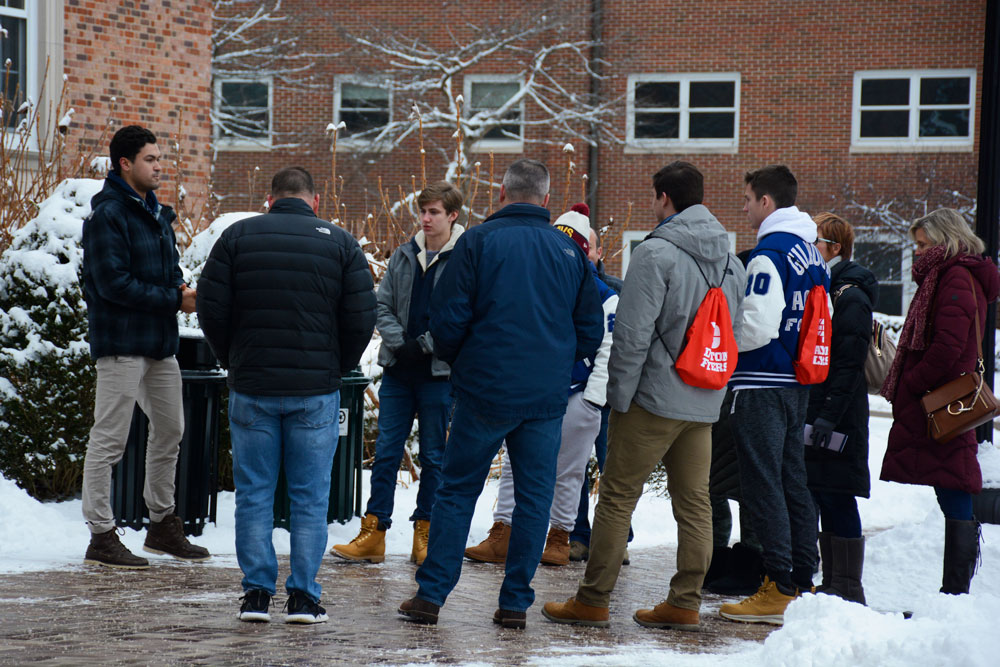 A campus tour guide speaks to a group of prospective students.