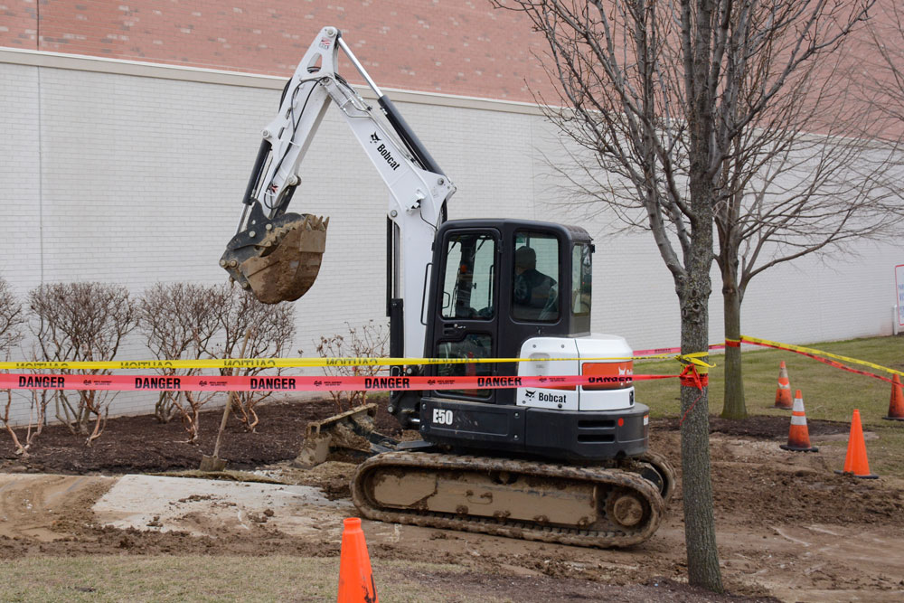A construction worker digs near Fitz Hall. 