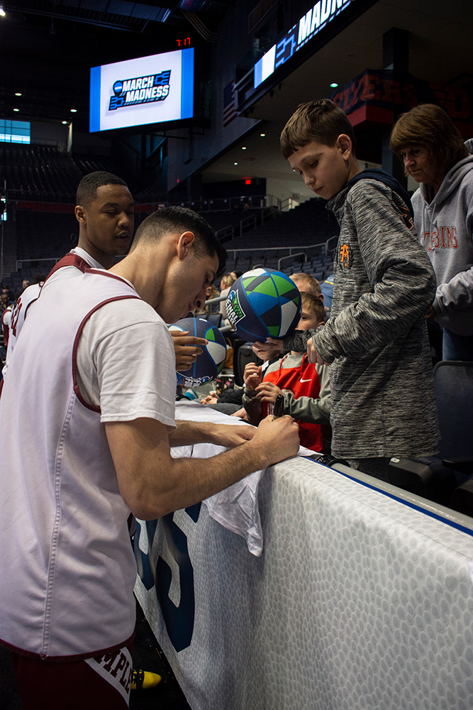 A basketball player signs shirts