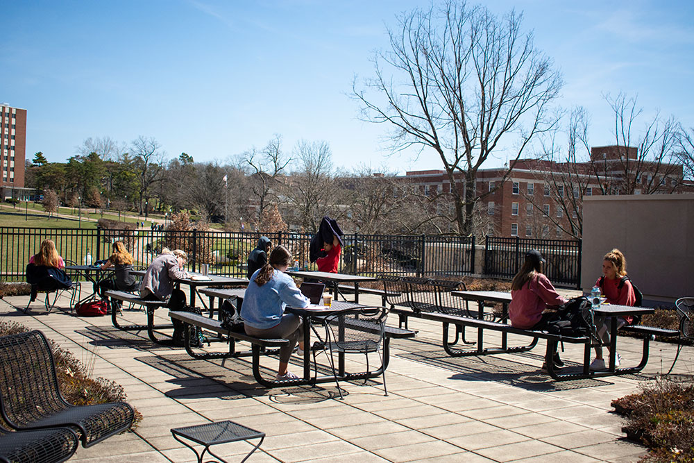 students sit outside in the sun
