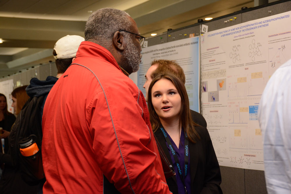 A student discusses their research during a poster session.