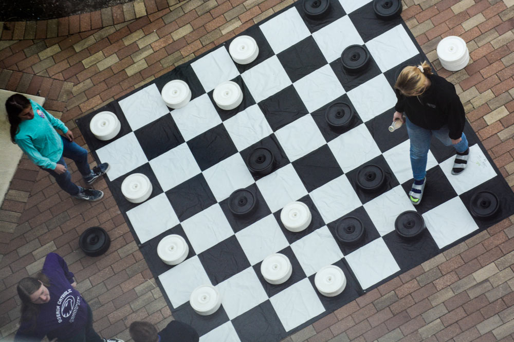 Students play a giant game of checkers.