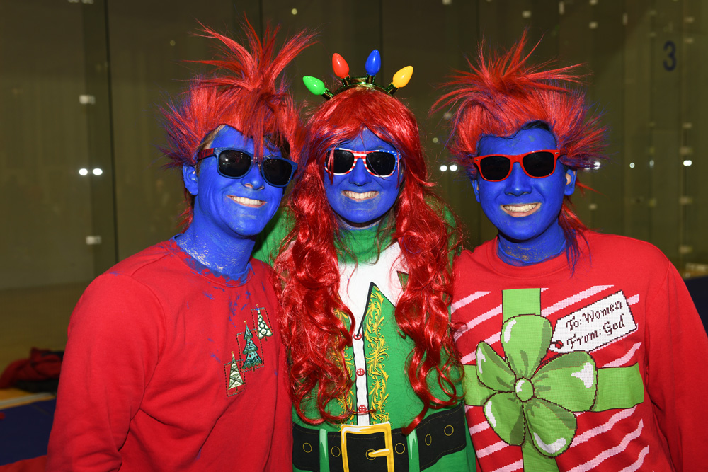 Three students in blue faces and red hair