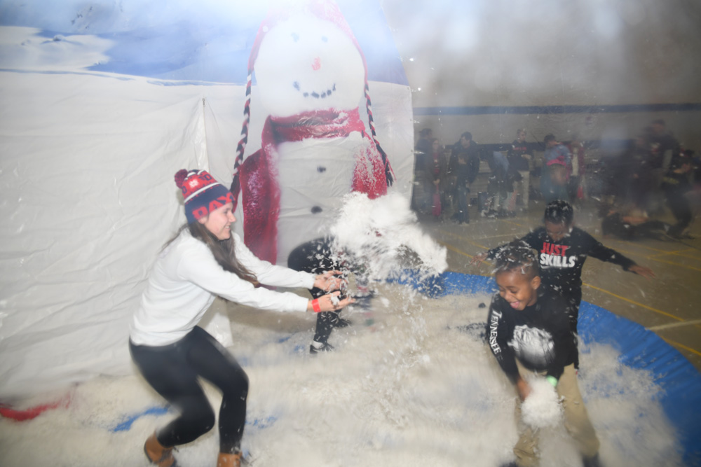Students and children throw snow at one another